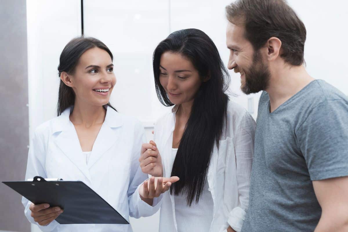 Before Your Dental Insurance Runs Out Three professionals discussing dental documents in a modern clinical office setting.